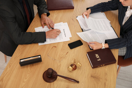 Lawyers working with papers during meeting at table in office, top view