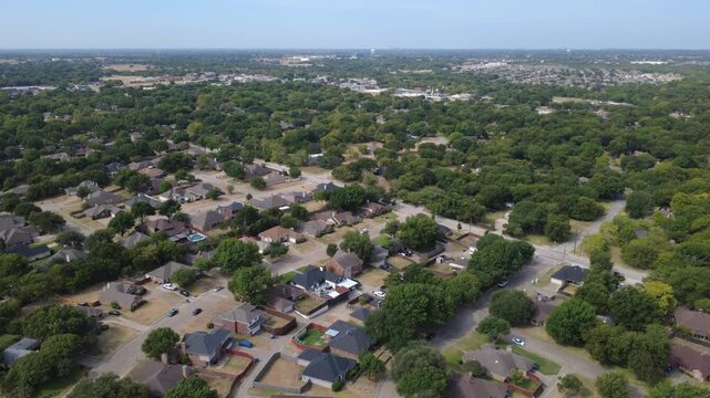 Broad collector roads cross leafy residential districts near Ernie Roberts Park. Single story ranch houses, paved thoroughfares integrate into dense oak tree canopies, DeSoto, Texas
