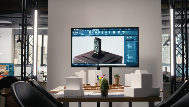 Empty modern office is prepared for real estate meetings and planning sessions, showcasing blueprints, 3D models and architectural software used for property investment projects and city planning.