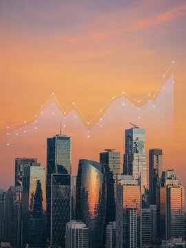 Modern glass skyscraper skyline at golden sunset with translucent upward trending line graph overlay symbolizing business growth and urban financial success in metropolitan cityscape