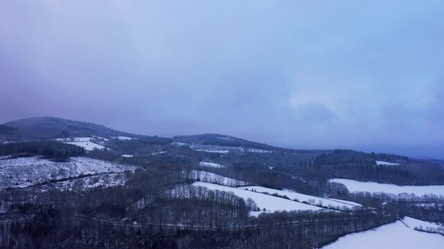 Wide aerial panoramic shot of the Morvan Forest and Haut Folin hills covered in snow during winter in Burgundy, France.