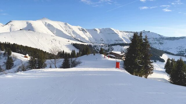 Wide view of a snow-covered ski slope in Megeve, located in the French Alps, Haute-Savoie, France. No people are visible, emphasizing the peaceful and untouched nature of the landscape.
