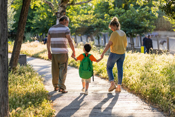 Fototapeta premium Three generations family walking child to school
