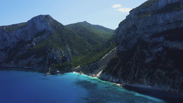 Aerial footage of Cala Goloritze, a famous beach near Baunei on the east coast of Sardinia, Italy. No people are visible in the frame, emphasizing the untouched and natural beauty of the location.