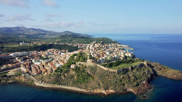 Aerial footage of the historic city center of Castelsardo, located on a rocky promontory overlooking the Mediterranean Sea in northern Sardinia, Italy. No people are visible in the scene.