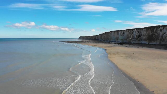 Wide aerial footage of the dramatic chalk cliffs and sandy beach at Veules-les-Roses on the Alabaster Coast in Normandy, France.