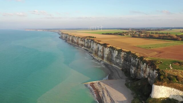 Drone footage showing the dramatic white chalk cliffs and coastline of Saint-Valery-en-Caux in Normandy, France. No people are visible, emphasizing the scale and tranquility of the landscape.