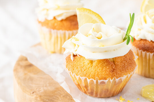 Lemon cupcakes topped with cream frosting and lemon
