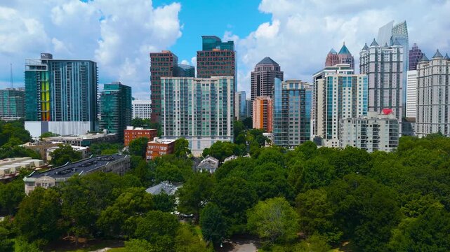 Aerial Drone Tracking Shot Over Piedmont Park and Midtown Atlanta Skyline Under Sunny Cloudscape