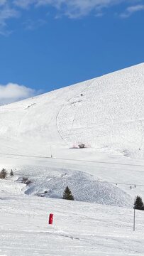 Vertical 9:16 video showing a wide, snow-covered ski slope at Megeve in the French Alps. No people are prominently visible in the frame, emphasizing the open, wintry landscape.