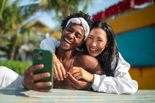 Happy moments by the beach, friends enjoying mobile connection, social media, and summer vibes