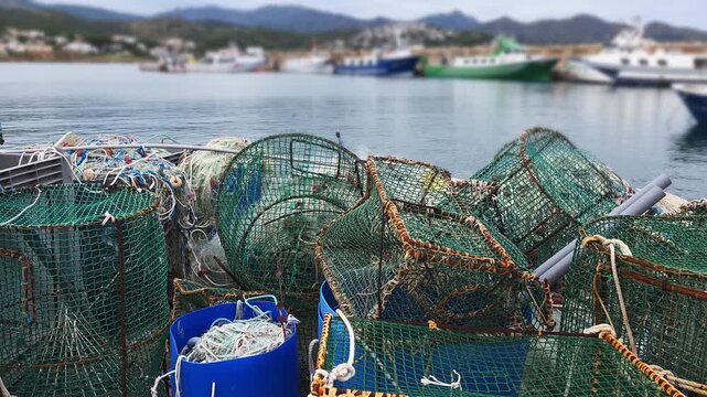 Nets and traps sit on the dock next to boats