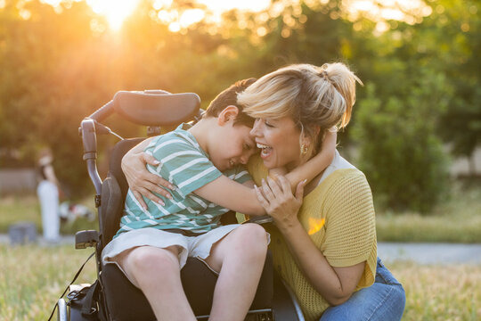 Mother hugging son with cerebral palsy in wheelchair