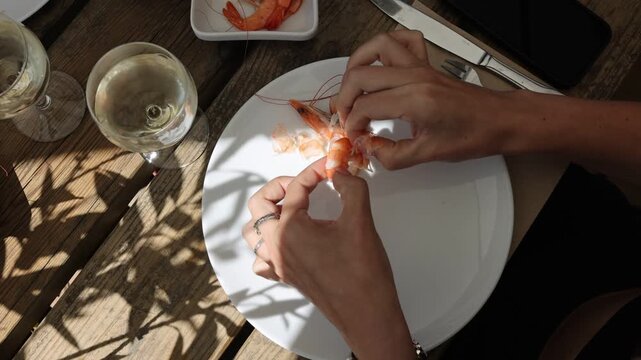 Woman Peeling and Cleaning a Shrimp from a Top View