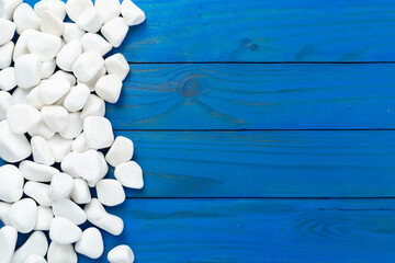 White pebble stones on wooden background, top view © Liami