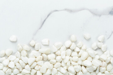 White pebble stones on marble background, top view © Liami