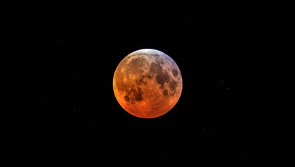 Naklejka premium A full moon appearing red during partial lunar eclipse.