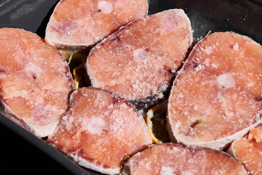 Raw pork slices in pan with coarse salt crystals ready for searing and cooking preparation close up, with pork, slice, raw, meat detail, showing salt, crystal, pan, skillet context