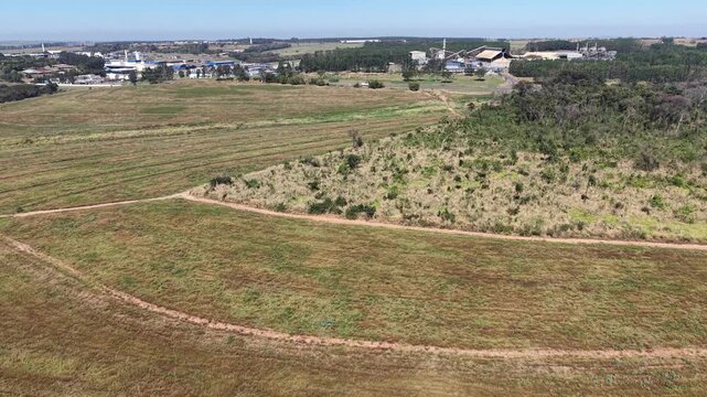 Aerial view of agricultural fields and industrial complex under a clear blue sky