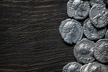 Top view of ancient Roman silver coins on a dark textured background. Close up of historical money and old collection. Concept of wealth and artifact. © scaliger