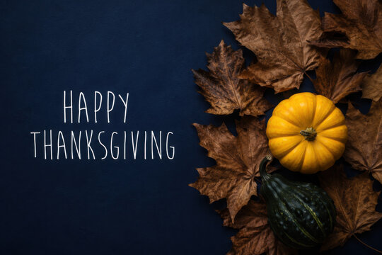 Happy Thanksgiving Day with maple leaves and pumpkin on blue background