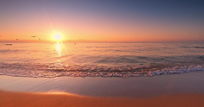 Golden sunrise with scenic cloudscape over sea horizon and beach shore