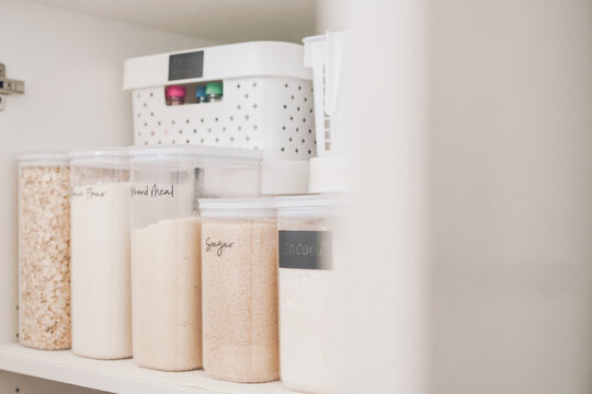 Pantry organization, kitchen storage, food containers, home organization, kitchen cabinet, clear canisters, decluttering solutions for a neat modern home interior with labels.