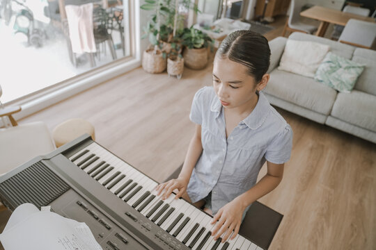 piano, keyboard, girl, music, playing, practice, student learning to play a digital instrument in a bright modern living room, focused young musician developing her talent at home.