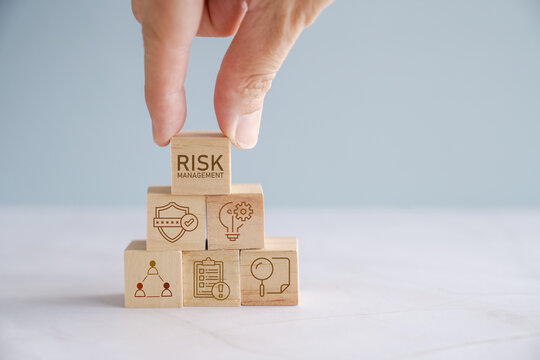 Hand holding wooden block with Risk management icons, business strategy concept

