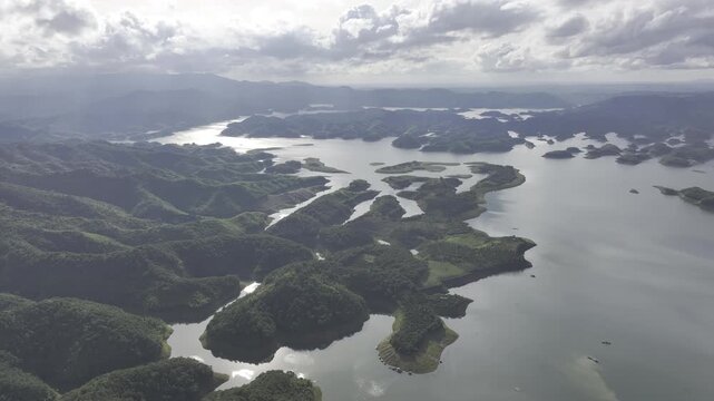 Aerial drone view of Ta Dung Lake surrounded by hundreds of green island hills and mountains in Ta Dung Commune, Lam Dong Province, Vietnam. View from QL 28. D Log mode