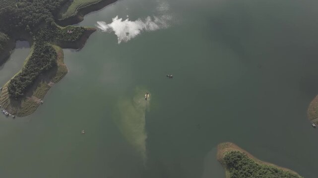 Aerial drone view of Ta Dung Lake surrounded by hundreds of green island hills and mountains in Ta Dung Commune, Lam Dong Province, Vietnam. View from QL 28. D Log mode