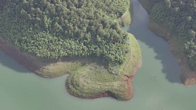 Aerial drone view of Ta Dung Lake surrounded by hundreds of green island hills and mountains in Ta Dung Commune, Lam Dong Province, Vietnam. View from QL 28. D Log mode