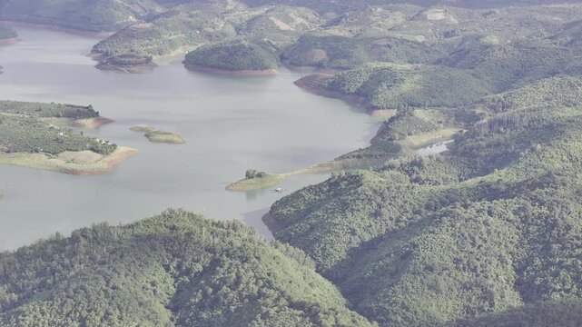 Aerial drone view of Ta Dung Lake surrounded by hundreds of green island hills and mountains in Ta Dung Commune, Lam Dong Province, Vietnam. View from QL 28. D Log mode