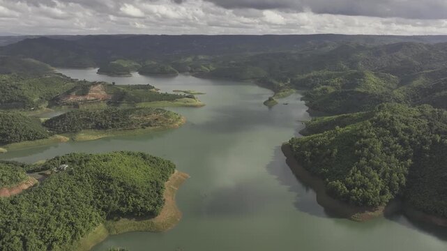 Aerial drone view of Ta Dung Lake surrounded by hundreds of green island hills and mountains in Ta Dung Commune, Lam Dong Province, Vietnam. View from QL 28. D Log mode