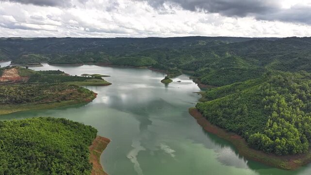 Aerial drone view of Ta Dung Lake surrounded by hundreds of green island hills and mountains in Ta Dung Commune, Lam Dong Province, Vietnam. View from QL 28. D Log mode