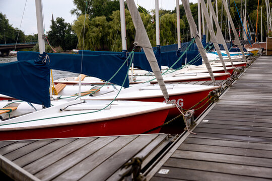 Sailing boats moored at a marina on the Au&szlig;enalster beneath a morning sky in Hamburg, Germany.