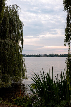 Panoramic view across the Au&szlig;enalster lake under a soft morning sky in Hamburg, Germany.