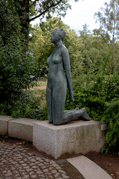 Bronze sculpture of a seated woman beside the Au&szlig;enalster lake in Hamburg, Germany.