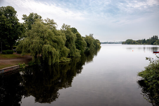 Panoramic view across the Au&szlig;enalster lake under a soft evening sky in Hamburg, Germany.