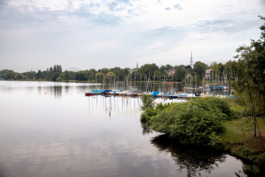 Sailing boats moored at a marina on the Au&szlig;enalster beneath a morning sky in Hamburg, Germany.