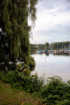 Sailing boats moored at a marina on the Au&szlig;enalster beneath a morning sky in Hamburg, Germany.