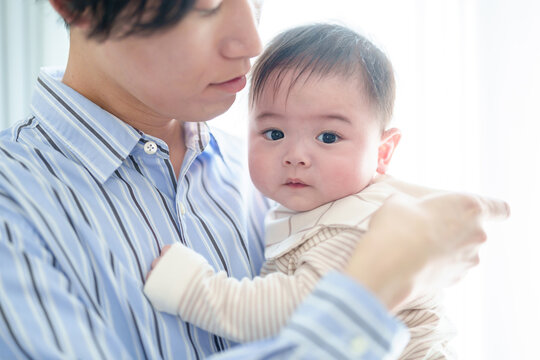 リビングで赤ちゃんを抱っこするお父さん　赤ちゃんの目線