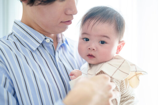 リビングで赤ちゃんを抱っこするお父さん　赤ちゃんの目線