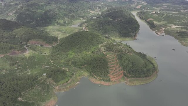 Aerial drone view of Ta Dung Lake surrounded by hundreds of green island hills and mountains in Ta Dung Commune, Lam Dong Province, Vietnam. View from QL 28. D Log mode