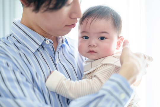 リビングで赤ちゃんを抱っこするお父さん　赤ちゃんの目線