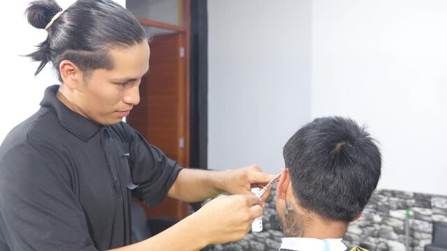 Professional hairstylist trimming client hair with scissors and comb