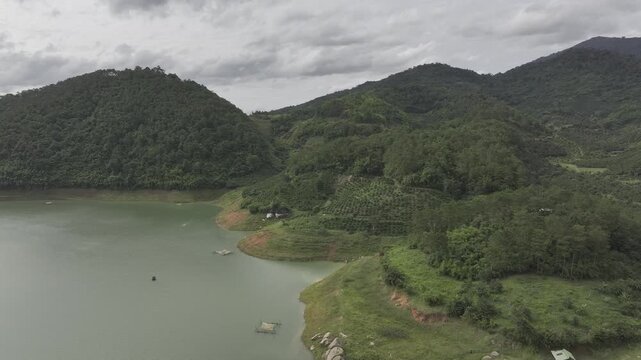 Aerial drone view of Ta Dung Lake surrounded by hundreds of green island hills and mountains in Ta Dung Commune, Lam Dong Province, Vietnam. View from QL 28. D Log mode
