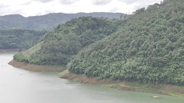 Aerial drone view of Ta Dung Lake surrounded by hundreds of green island hills and mountains in Ta Dung Commune, Lam Dong Province, Vietnam. View from QL 28. D Log mode