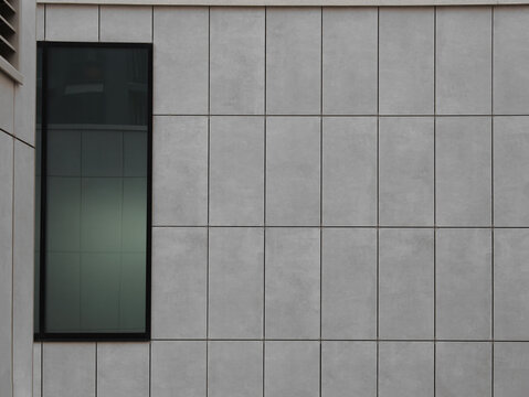 exterior tile tiled grey gray modern wall of a contemporary commercial style building with aluminum metal composite panels and narrow vertical glass window