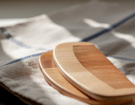 handcrafted natural sandalwood hair comb set against a folded linen textile in soft morning light